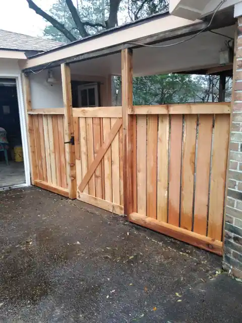 New cedar fence panels and a Z-brace gate beside a carport