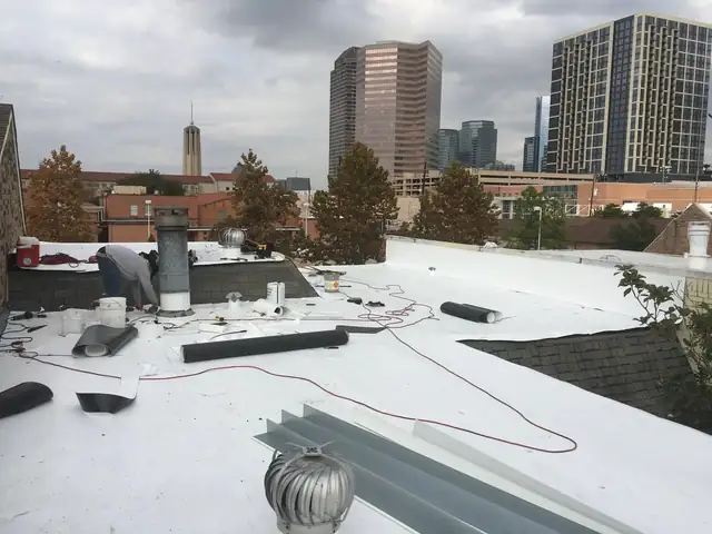 White commercial flat roof with Houston high-rises in the background