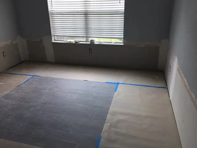 Room being rebuilt with new floor underlayment and a taped-out layout
