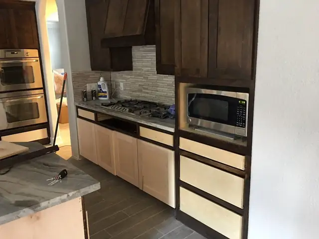New kitchen cabinets with a cooktop and tile backsplash