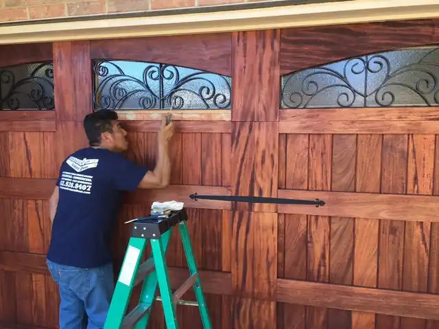 Craftsman fitting a custom mahogany garage door